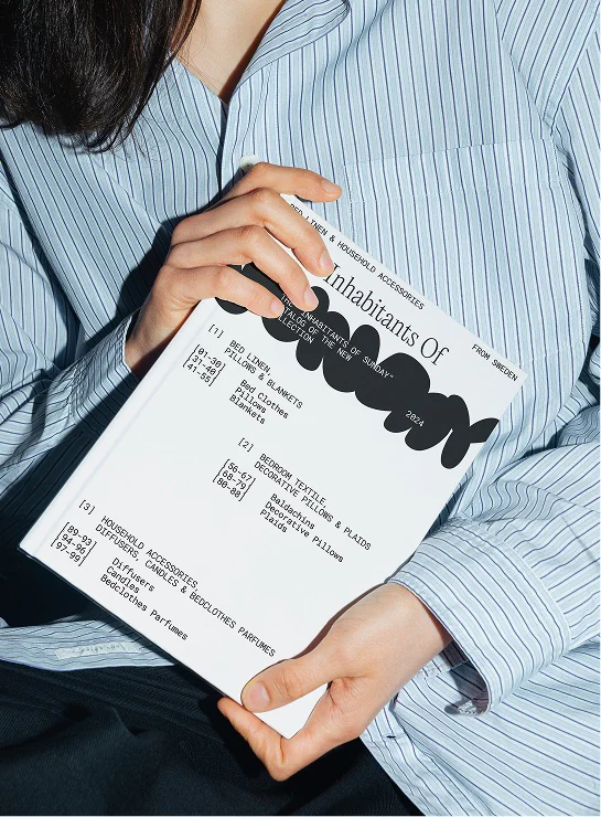 Catalogue held against a striped shirt